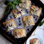 Living the Gourmet: Baked into a delicate, buttery crust, these Blueberry Basil Hand Pies are bursting with the flavors of the summer.