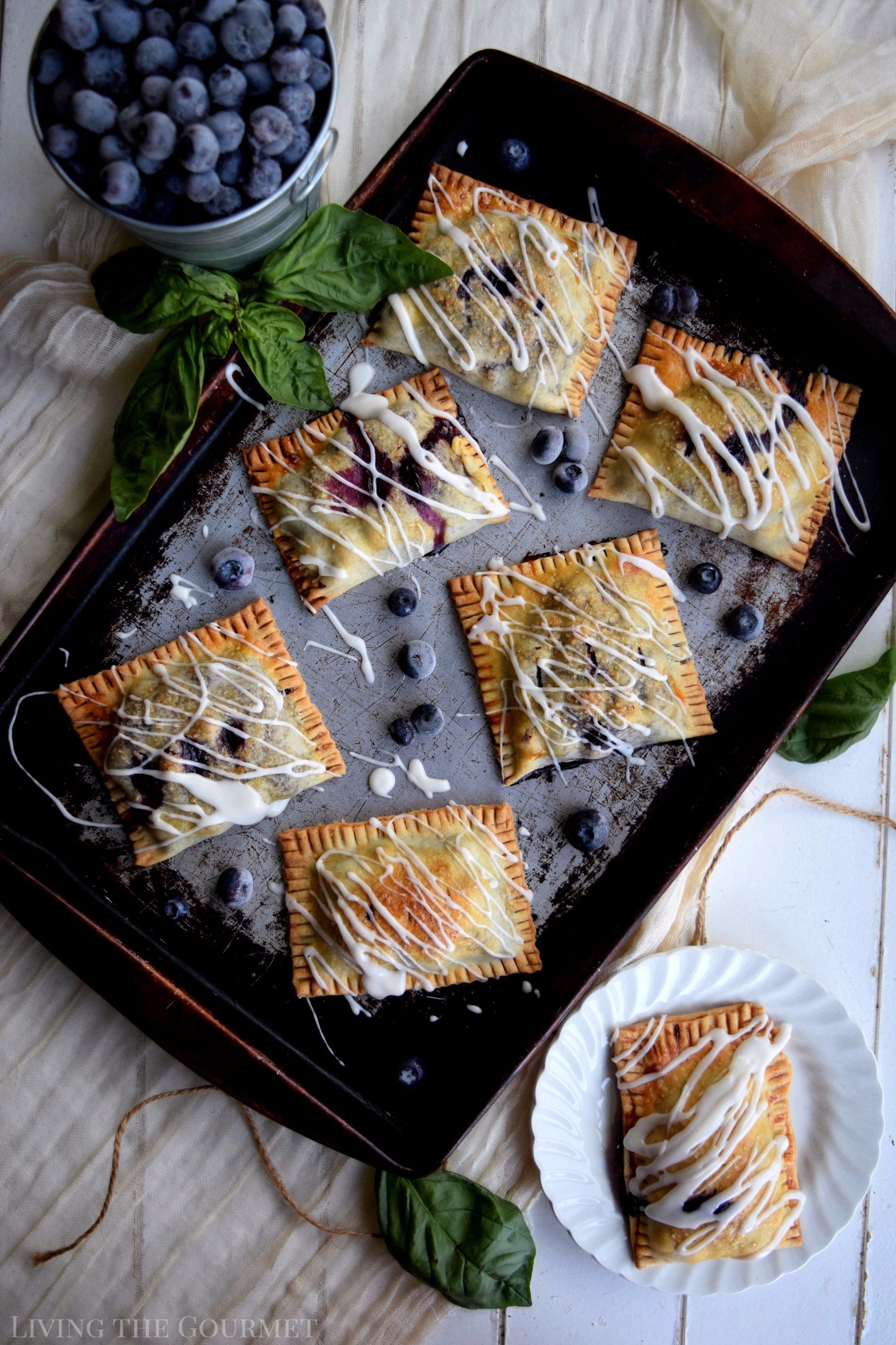 Living the Gourmet: Baked into a delicate, buttery crust, these Blueberry Basil Hand Pies are bursting with the flavors of the summer.