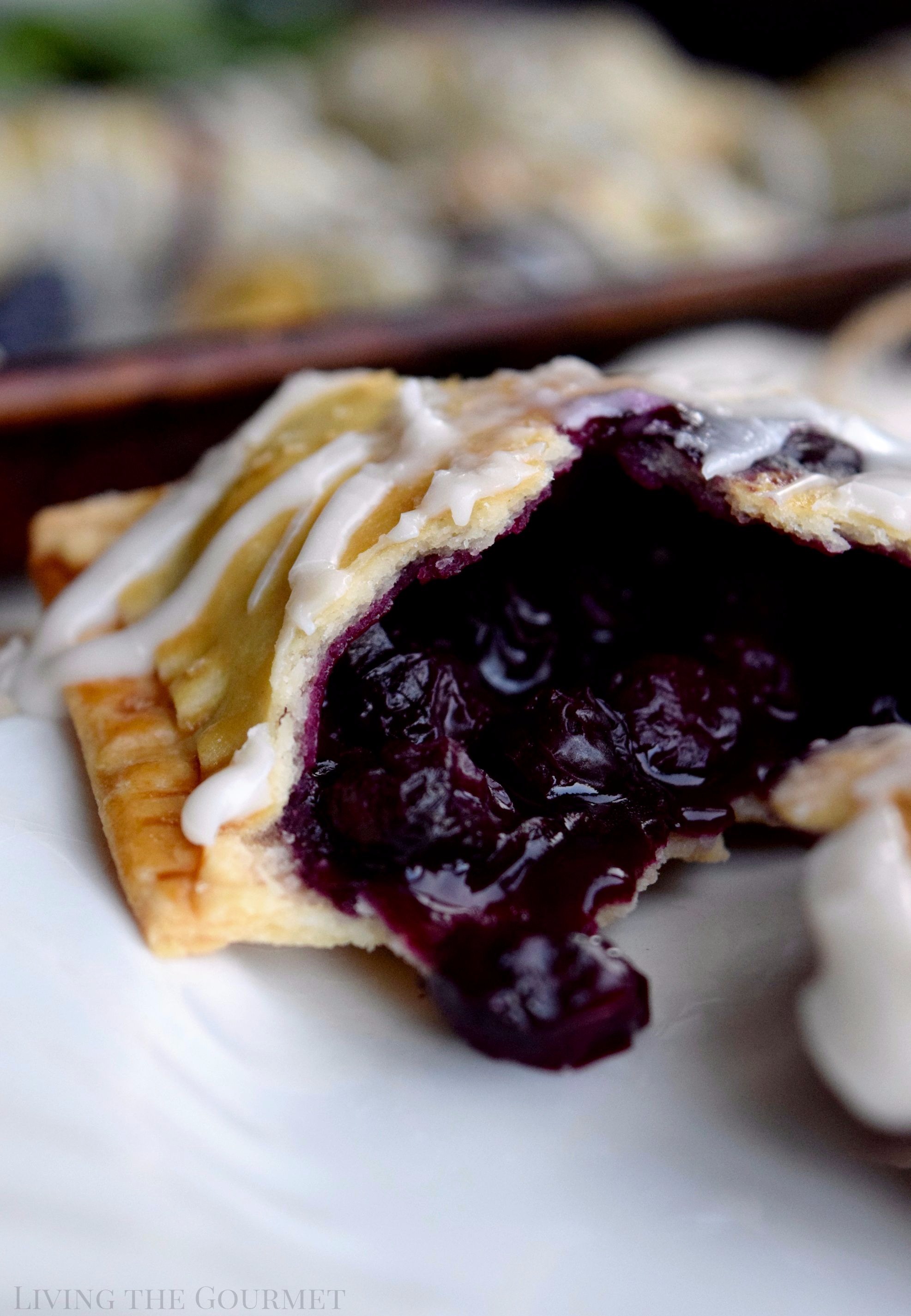 Living the Gourmet: Baked into a delicate, buttery crust, these Blueberry Basil Hand Pies are bursting with the flavors of the summer.