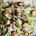 Today's Caesar Salad starts off with crisp Romaine lettuce leaves, thinly sliced red onions, and crunchy cucumbers, tossed with savory Parmesan cheese and golden croutons.