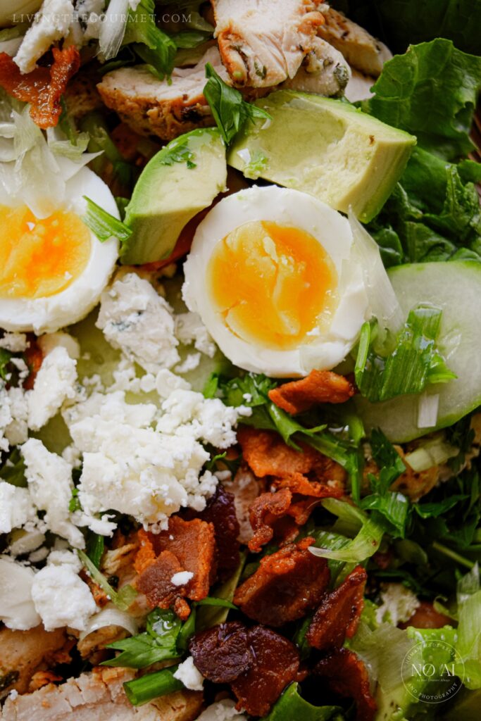 Cobb salad feature grilled chicken, bacon, jammy eggs, avocado, cheese, and tossed greens