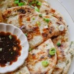 Close-up of a flaky scallion pancake showing crisp golden layers and fresh scallions