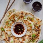 Golden scallion pancakes cut into wedges and arranged on a serving platter