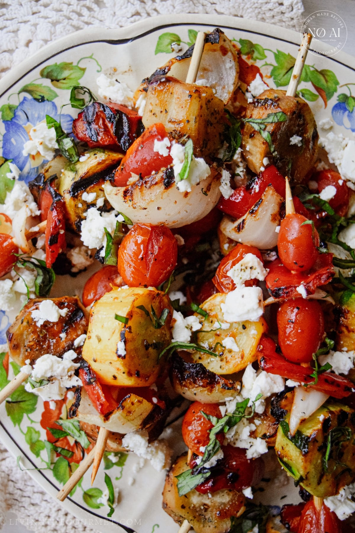 Grilled vegetable skewers for summer topped with marinated feta and garden basil.
