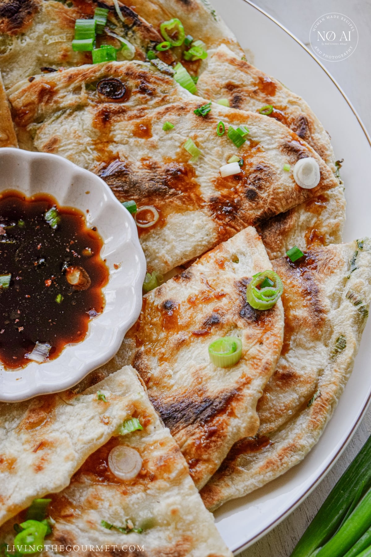 Golden scallion pancakes cut into wedges and arranged on a serving platter