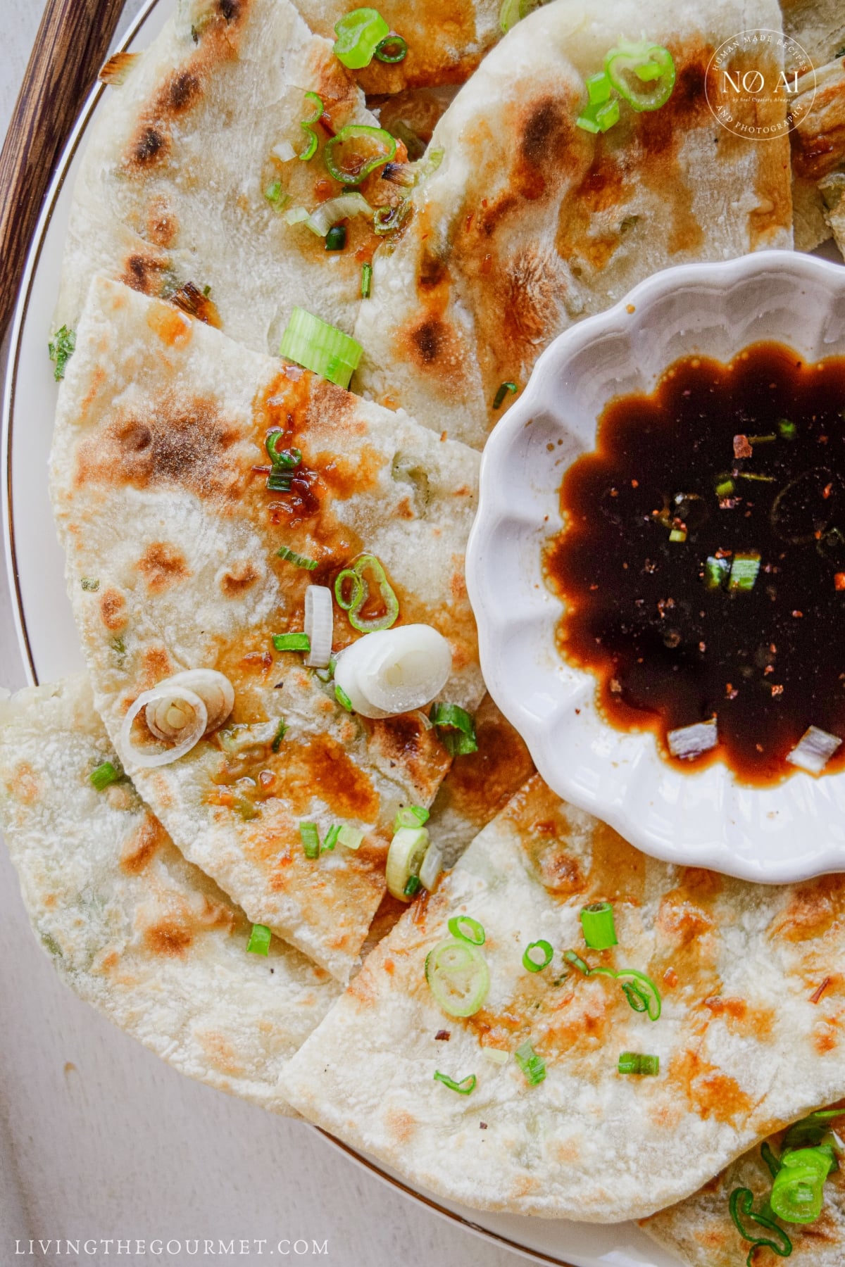 Close-up of a flaky scallion pancake showing crisp golden layers and fresh scallions