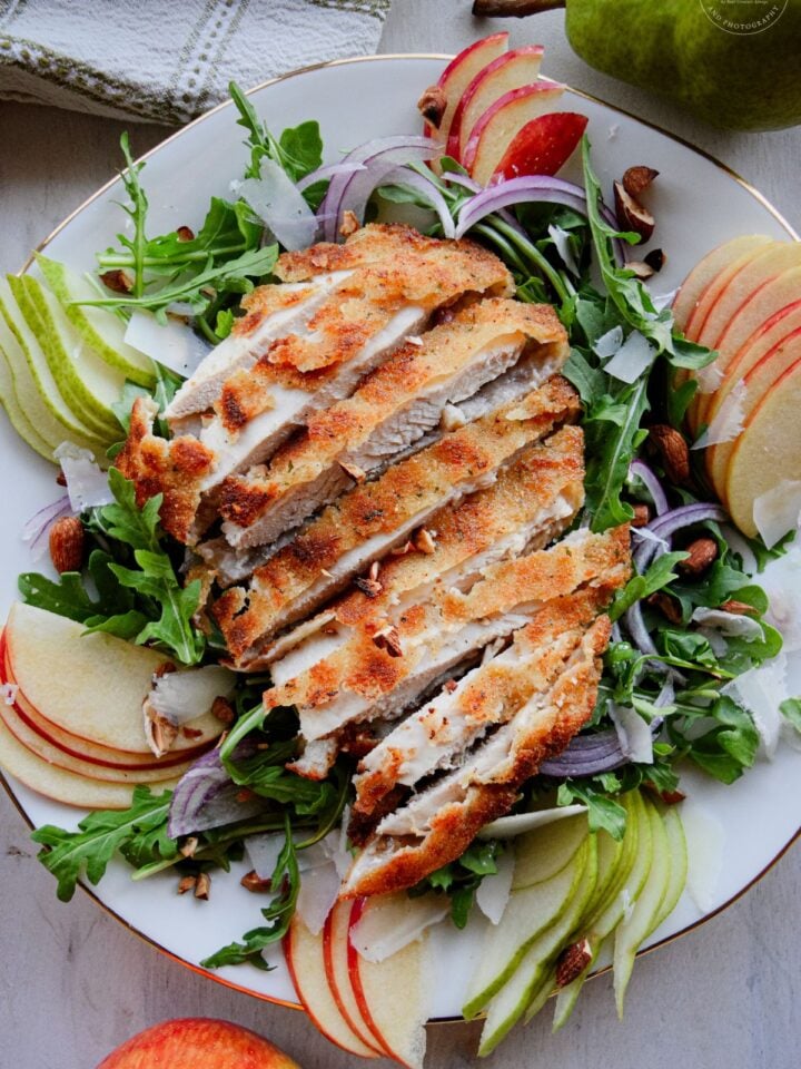 Golden pan-fried breaded chicken cutlets sliced over a fresh bed of arugula, sliced pears, apples, red onions, and toasted almonds